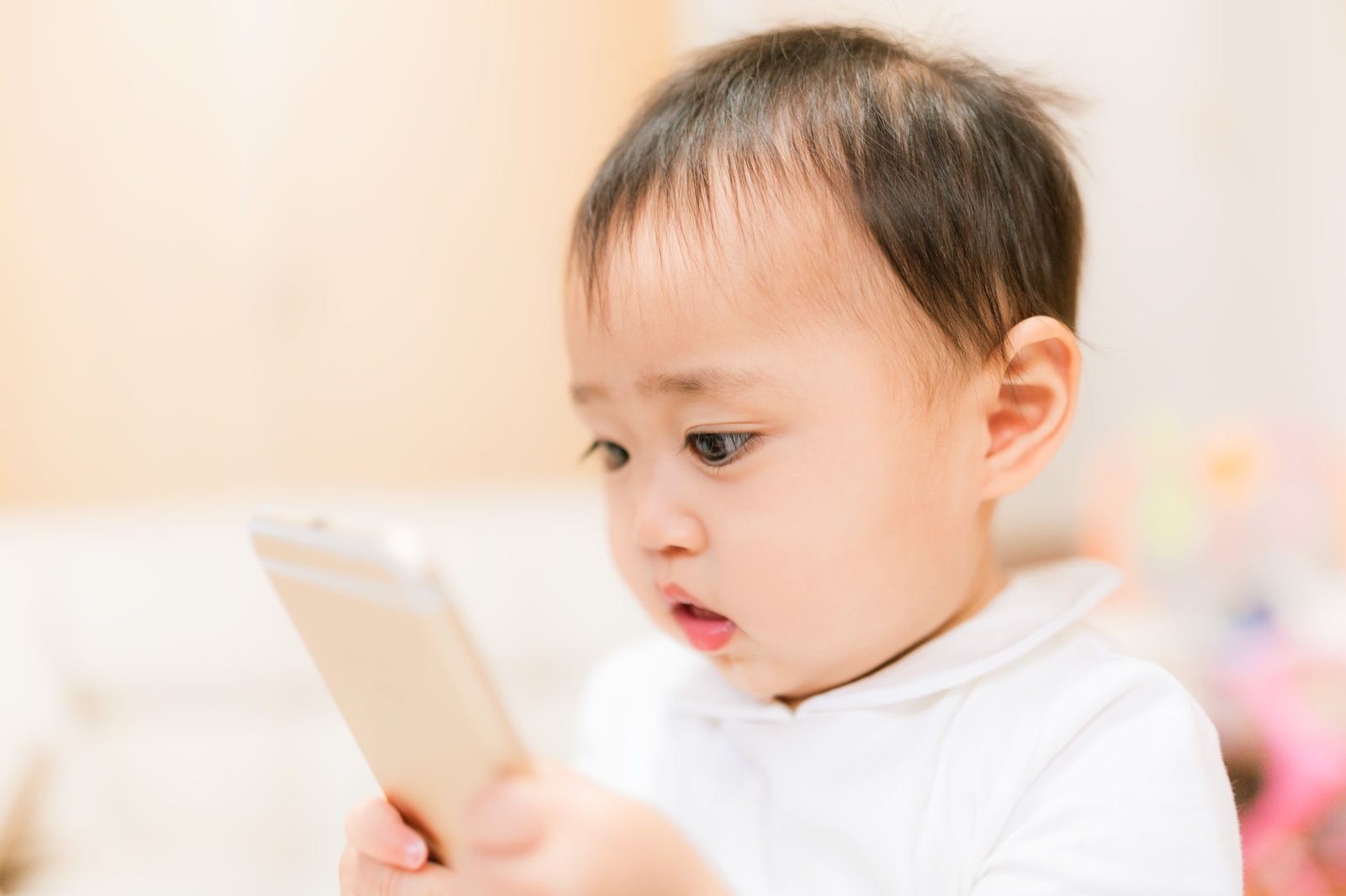 This article focuses on local government regulations in Japan regarding children's smartphone use. The eye-catching image shows a baby holding a smartphone, making it clear that the article is about smartphone use by minors.