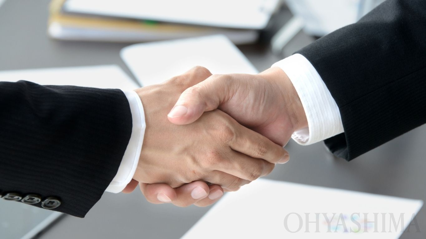 Hinoki raises $20m. Two businesspeople shaking hands, marking this as an article about business succession, partnership and M&A.